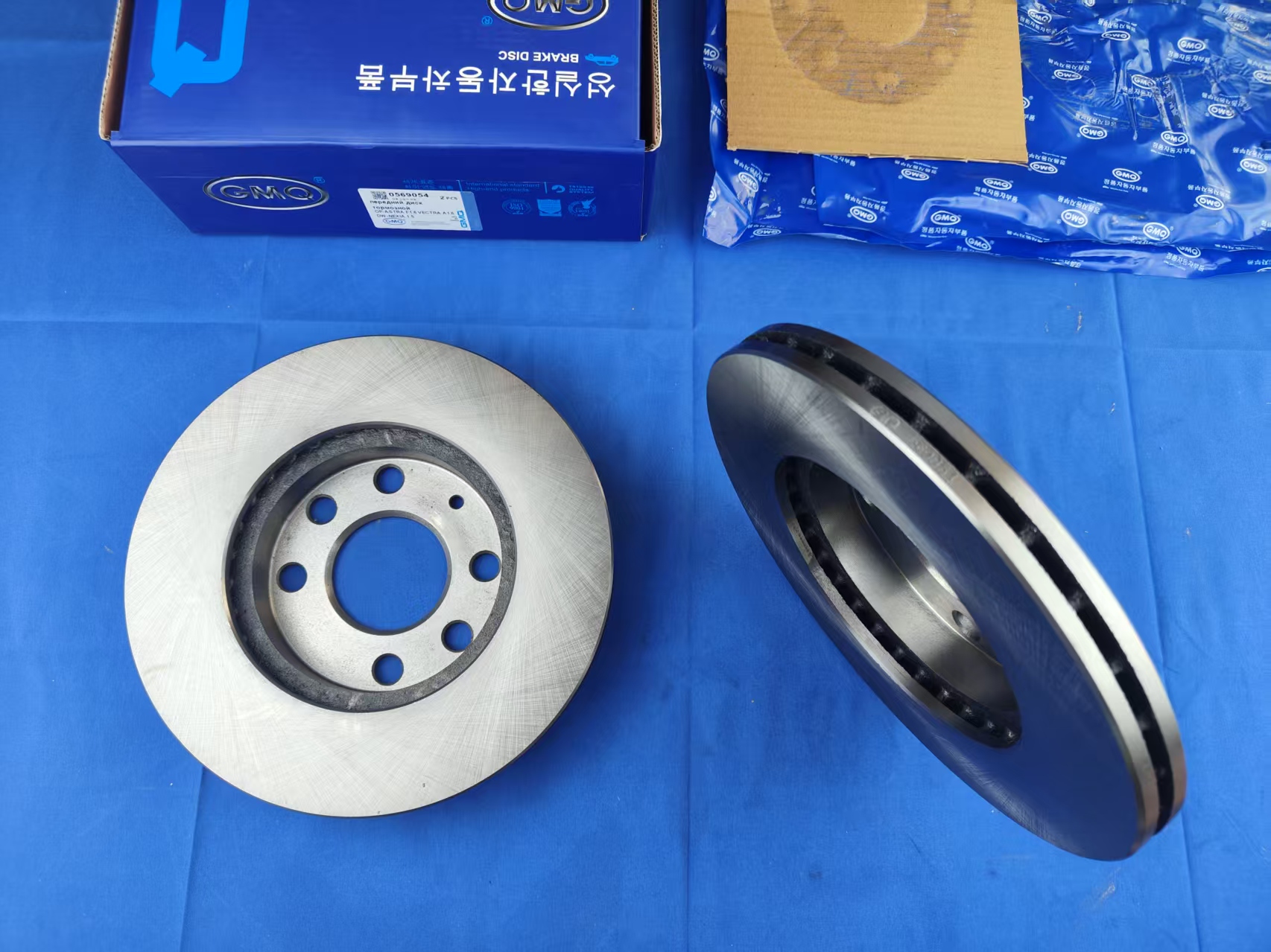 GMQ Brake Disc OEM 0569054 - 45 degree side view showing vented disc construction and GMQ packaging